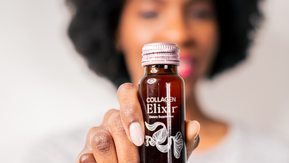 Woman holding bottle of marine collagen